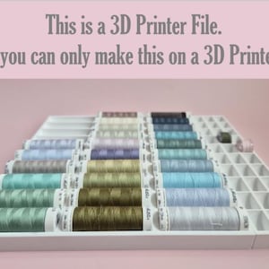 May include: A white tiered organizer filled with spools of thread in various colors, including green, blue, and purple. The text on the image reads: "This is a 3D Printer File. So you can only make this on a 3D Printer!!"