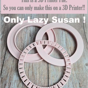 May include: Three light pink 3D printed rings for a Lazy Susan mechanism. The text reads: This is a 3D Printer File. So you can only make this on a 3D Printer!! Only Lazy Susan ! The rings feature a smooth finish and a circular bearing track.