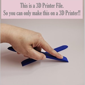 May include: A hand touching a dark blue 3D printed object. The object is composed of two curved pieces that intersect. Text in the image reads: "This is a 3D Printer File. So you can only make this on a 3D Printer!!"