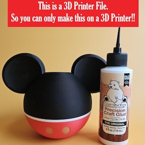 May include: A 3D-printed Mickey Mouse-shaped planter with black ears, a black head, and a red and white base. Next to it is a bottle of Bearly Art Precision Craft Glue, 4 fl oz (118 mL). The red banner at the top reads: "This is a 3D Printer File."