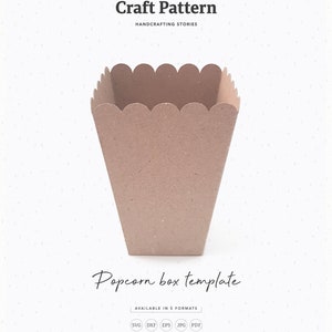 May include: A brown paper popcorn box template, with a scalloped top edge. The template is available in five formats: SVG, DXF, EPS, JPG, and PDF. The text "Popcorn box template" is written in cursive below the box. The text "Craft Pattern" is written in black at the top of the image, with the text "Folktale" above it. The text "Handcrafting Stories" is written in black below "Craft Pattern". The text "Die Cut" is written in black at the bottom left of the image. The text "No. 331" is written in black at the bottom right of the image.