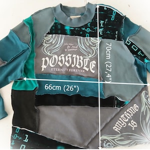 May include: A patchwork sweatshirt in shades of teal, gray, and black, with the word "POSSIBLE" in a stylized font. The sweatshirt measures 26 inches wide and 27.4 inches long. The text "Anything is" is also visible.