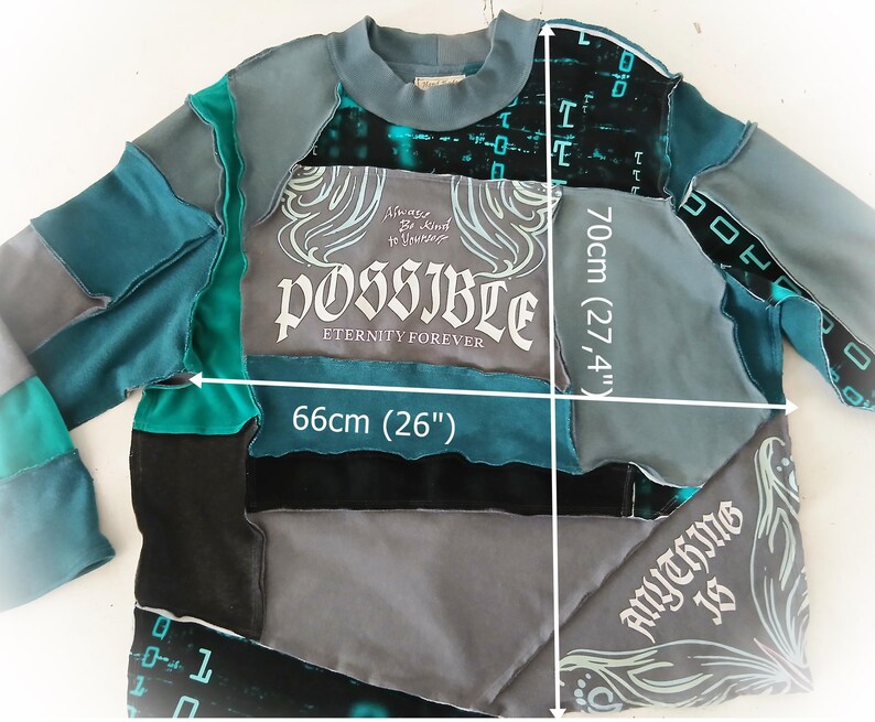 May include: A patchwork sweatshirt in shades of teal, gray, and black, with the word "POSSIBLE" in a stylized font. The sweatshirt measures 26 inches wide and 27.4 inches long. The text "Anything is" is also visible.