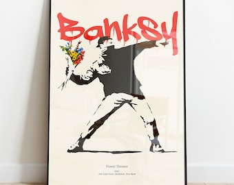 Puede incluir: Una impresión en blanco y negro de una persona lanzando un ramo de flores. La persona lleva una chaqueta negra con capucha y pantalones negros. El fondo es blanco con la palabra "Banksy" en pintura roja en aerosol. El texto debajo de la imagen dice "Flower Thrower 2003 Ash-Salem Street, Bethlehem, West Bank."