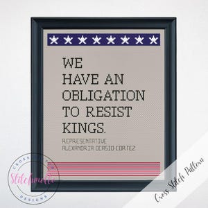 Puede incluir: Arte de punto de cruz enmarcado con un marco negro. El diseño presenta el texto "WE HAVE AN OBLIGATION TO RESIST KINGS." y el nombre "ALEXANDRIA OCASIO-CORTEZ." Tiene un patrón de estrellas azules y blancas y rayas rojas en la parte superior e inferior.