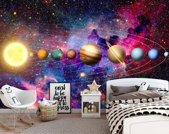 Puede incluir: Un mural de pared con un fondo de galaxia vibrante con el sol y los planetas dispuestos en un diseño de sistema solar. La habitación incluye una mecedora blanca, una cesta tejida, un letrero con texto, una mesita de noche y una cama.