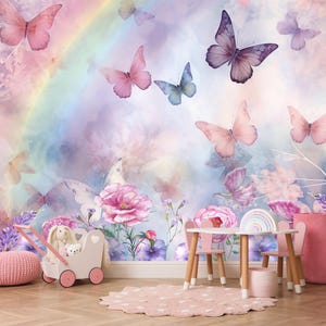 May include: A wall mural featuring a soft watercolour background with a rainbow, pink and purple flowers, and various butterflies in shades of pink, blue, and purple. The scene includes a white toy stroller, a pink pouf, and a small wooden table set.