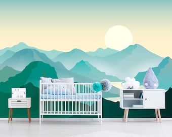 May include: A white crib sits in front of a wall mural featuring layered teal and green mountains under a pale yellow sky with a large sun. To the left is a white nightstand with a sign reading KID ROOM. To the right is a white storage unit.