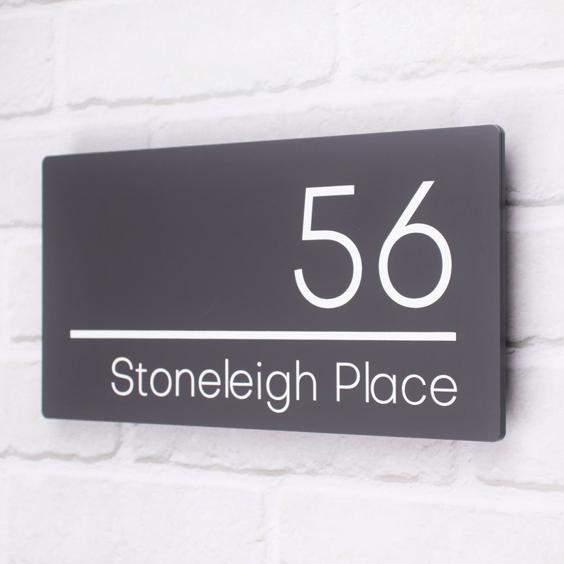 May include: A dark gray house number sign with white lettering. The number 56 is displayed above the text "Stoneleigh Place".