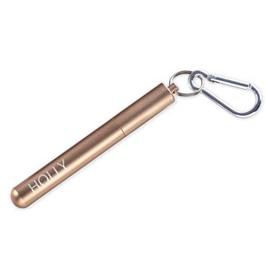May include: A gold-colored metal straw case with a carabiner clip. The case has the word "HOLLY" engraved on it.