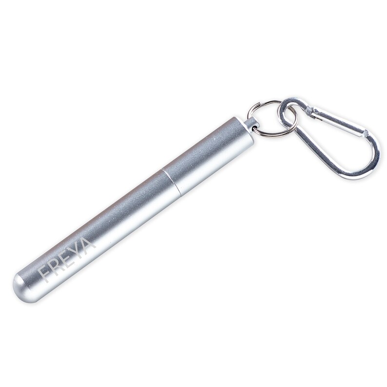 May include: Silver metal straw with a carrying case and a carabiner clip. The case has the word "FREYA" engraved on it.
