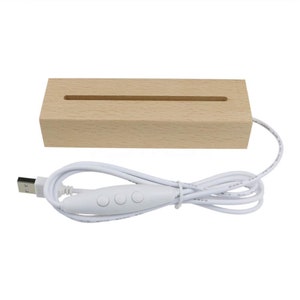 May include: A wooden display stand with a slot for displaying small items. The stand is lit by a white LED strip that is powered by a USB cable with a three-button switch.