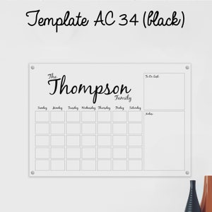 May include: White dry-erase board with a black frame and a monthly calendar grid. The board has a to-do list and notes section. The text "The Thompson Family" is written at the top of the board.