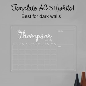 May include: White acrylic dry-erase calendar with a grid for each day of the week, a to-do list section, and a notes section. The calendar has the text "The Thompson Family" at the top.