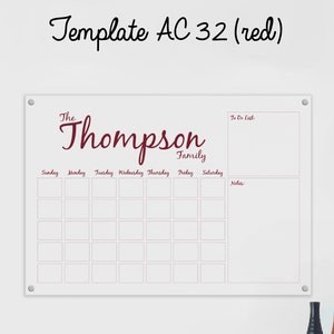May include: White dry-erase board with a burgundy border and grid. The board has a section for a to-do list, notes, and a weekly calendar. The text "The Thompson Family" is written in burgundy cursive at the top of the board.