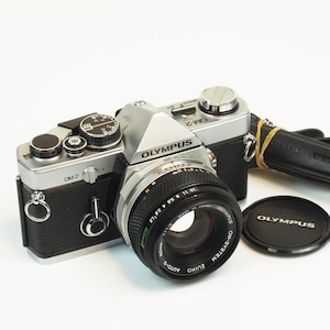 Appareil photo argentique Olympus OM-2N + 50mm f1.8 F.Zuiko Auto-S Noir Reconditionné - Appareil