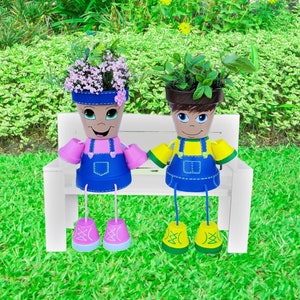 May include: Two painted flower pots with faces, wearing overalls and shoes, sitting on a white bench. The pot on the left has pink overalls and pink shoes, and the pot on the right has yellow overalls and yellow shoes.