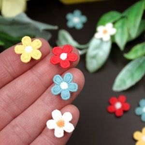 May include: Assortment of small embroidered flower patches in various colors, including yellow, red, blue, and white. The patches are about 1 inch in diameter and have a simple, classic design.