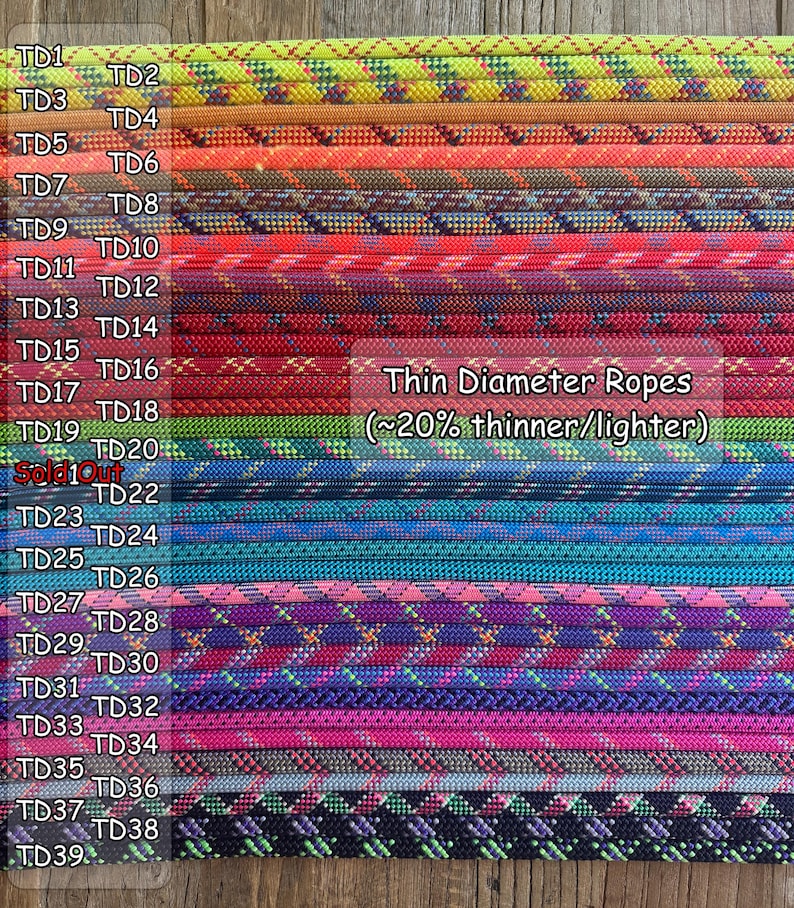 Puede incluir: Una colecci&oacute;n de cuerdas de di&aacute;metro fino dispuestas en filas horizontales, cada una con patrones de colores distintos y etiquetadas con c&oacute;digos de TD1 a TD39. El texto Thin Diameter Ropes (~20% thinner/lighter) es visible a la derecha.