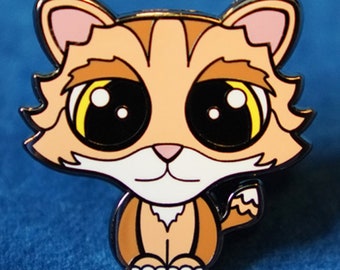 Puede incluir: Un pin de esmalte de un gato de dibujos animados con ojos grandes, pelaje naranja y pecho blanco. El pin está sobre un fondo azul.