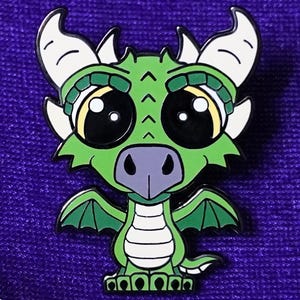 May include: A green dragon enamel pin with large, expressive eyes and small wings. The dragon has white horns and a light green headpiece. The pin is set against a purple background, with the "Paw & Pins Fantasy" logo in the bottom left corner.
