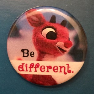 以下が含まれることがあります： 大きな目の漫画のトナカイと「Be different.」というテキストが書かれた赤と白のボタン