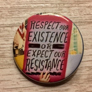 May include: A pink button with the text "Respect our existence or expect our resistance" in black lettering.
