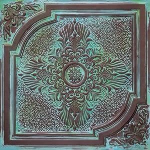 May include: A decorative ceiling tile with a brown, ornate design on a teal background. The tile has a raised, embossed pattern with a central floral motif.