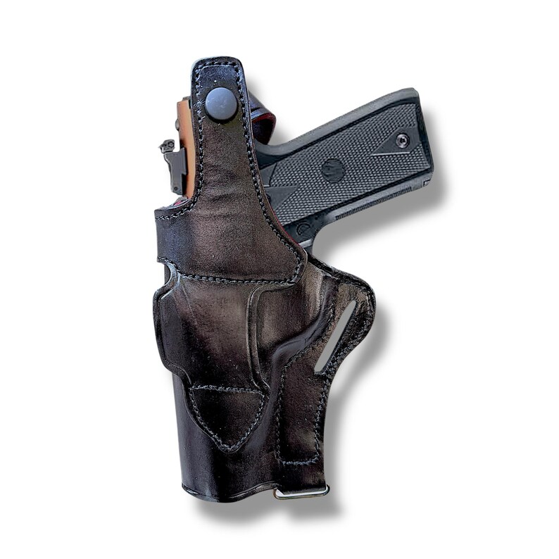 May include: A black leather holster with a gun inside. The holster is designed to be worn on the hip. The gun is black and has a textured grip. The holster has a snap closure and a belt loop.