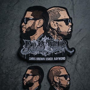 May include: Embroidered patches featuring side profiles of two men wearing sunglasses. The larger patch reads "R&B TOUR" with the names "CHRIS BROWN USHER RAYMOND" below. Two smaller patches show the same profiles.
