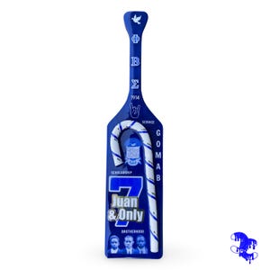 Pode incluir: Uma pá azul com detalhes brancos e dourados, com texto e gráficos. A pá tem uma pomba no topo, letras gregas e as palavras "Juan & Only" e "Brotherhood". É um item decorativo único.