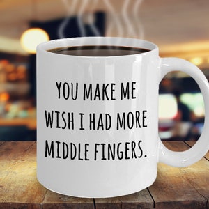 May include: White ceramic coffee mug with black text that reads "You make me wish I had more middle fingers."