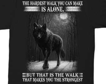 Puede incluir: Camiseta negra con un lobo negro caminando en un bosque. El texto dice: "THE HARDEST WALK YOU CAN MAKE IS ALONE, BUT THAT IS THE WALK THAT MAKES YOU THE STRONGEST."