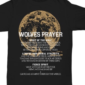 Puede incluir: Camiseta negra con un gráfico de cabeza de lobo y luna marrón. El texto "Wolves Prayer" está impreso en marrón sobre el gráfico. El texto debajo del gráfico dice: "Spirit of the wolf. You who wanders the wildlands. You who stalks in silent shadows. You who runs and leaps between the moss covered trees. Lend me your primal strength. And the wisdom of your glowing eyes. Teach me to relentlessly track my desires. And to stand in defense of those I love. Pierce spirit. Walk with me in my solitude. Howl with me in my joy. & Gaurd me as I move through this world."