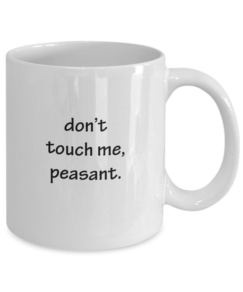 May include: White ceramic mug with a curved handle. The mug features the phrase "don't touch me, peasant" in black, sans-serif font. The mug is designed for hot beverages and has a standard size.