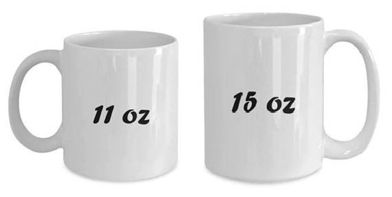 May include: Two white ceramic mugs. The mug on the left has "11 oz" printed on it, and the mug on the right has "15 oz" printed on it. Both mugs have a curved handle.