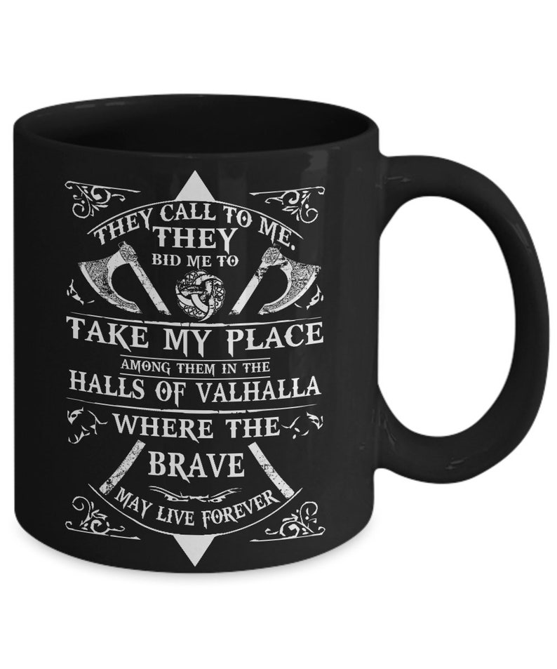 May include: Black coffee mug with white text and graphic. The text reads "They call to me. They bid me to take my place among them in the halls of Valhalla where the brave may live forever".