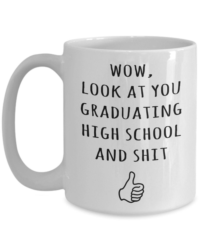 May include: White ceramic coffee mug with a black graphic that says "WOW, LOOK AT YOU GRADUATING HIGH SCHOOL AND SHIT" with a thumbs up emoji.