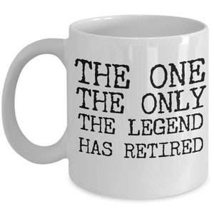 K&ouml;nnte beinhalten: Wei&szlig;e Keramik-Kaffeetasse mit schwarzem Text, der "The One The Only The Legend Has Retired" lautet.