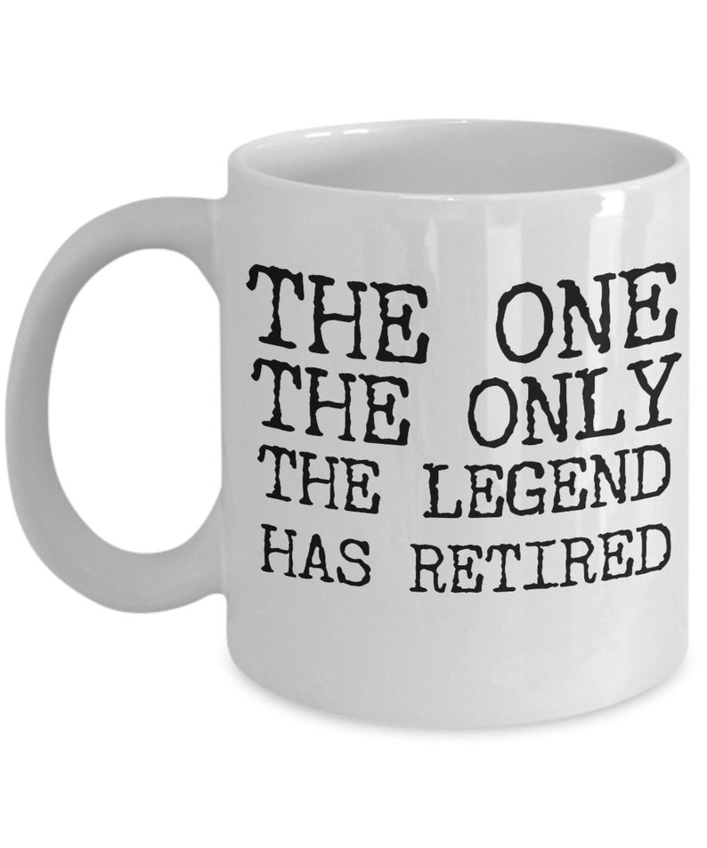 K&ouml;nnte beinhalten: Wei&szlig;e Keramik-Kaffeetasse mit schwarzem Text, der "The One The Only The Legend Has Retired" lautet.