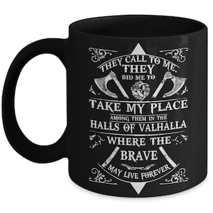 May include: Black coffee mug with a white design featuring a Viking axe, a knotwork design, and the text "They call to me. They bid me to take my place among them in the halls of Valhalla where the brave may live forever."