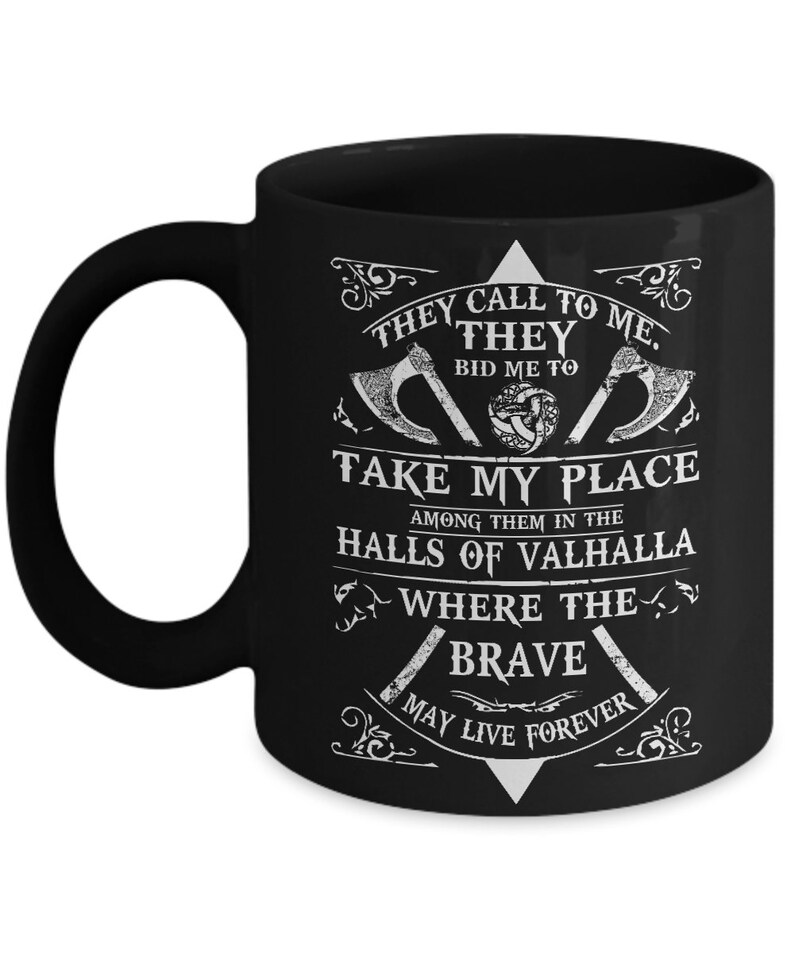 May include: Black coffee mug with a white design featuring a Viking axe, a knotwork design, and the text "They call to me. They bid me to take my place among them in the halls of Valhalla where the brave may live forever."
