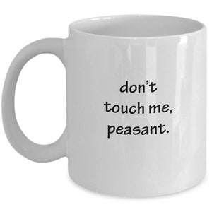 May include: White ceramic mug with a curved handle. The mug features the black text "don't touch me, peasant."