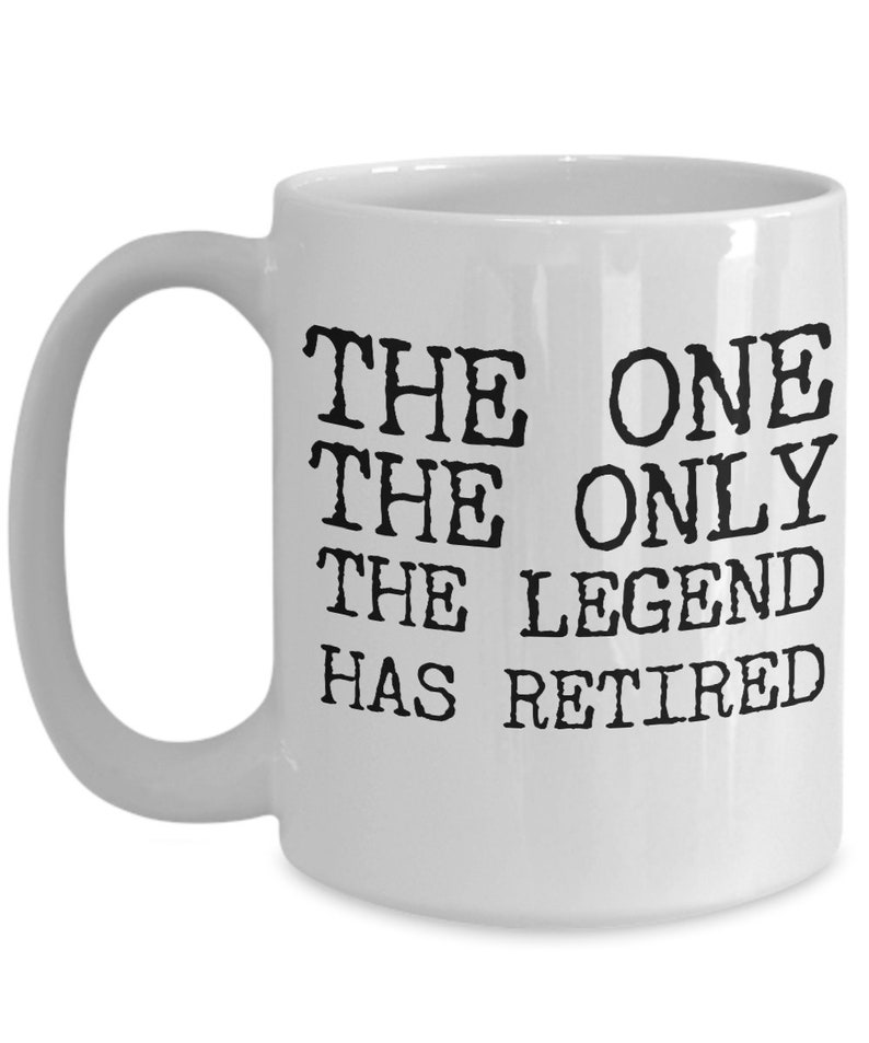 K&ouml;nnte beinhalten: Wei&szlig;e Keramik-Kaffeetasse mit schwarzem Text, der "The One The Only The Legend Has Retired" lautet.