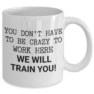 May include: White ceramic coffee mug with black text that reads "You don't have to be crazy to work here, we will train you!"