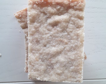 Può includere: Due biscotti quadrati di shortbread impilati uno sopra l'altro. I biscotti sono di colore marrone chiaro e hanno una consistenza granulosa.