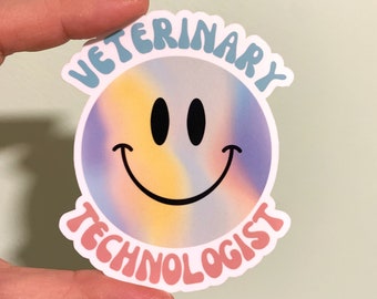 Può includere: Un adesivo con una faccina sorridente e la scritta "VETERINARY TECHNOLOGIST". La faccina sorridente ha uno sfondo sfumato di giallo, viola e blu. Il testo è in azzurro e rosa, con un font retrò.