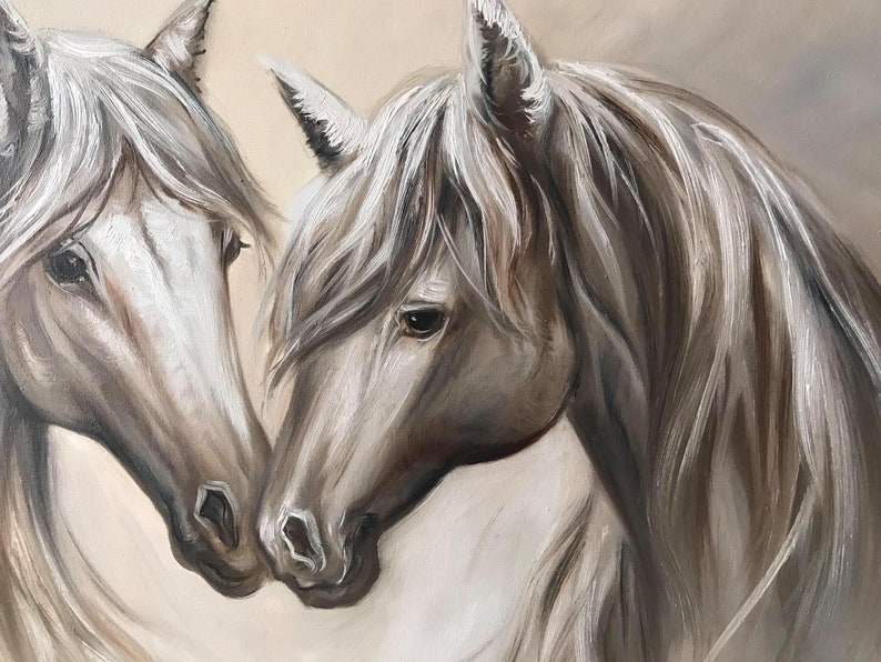 May include: An oil painting depicts two horses in a tender embrace. The horses' heads are close, with soft, flowing manes in shades of white and gray. The background is a warm, neutral tone, enhancing the focus on the equine subjects.