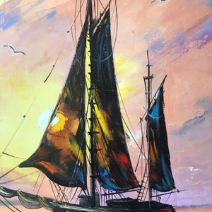 May include: A painting of a black sailboat with sails billowing in the wind. The sailboat is in the foreground of the painting, with a sunset sky in the background. The sky is painted in shades of pink, orange, and yellow.