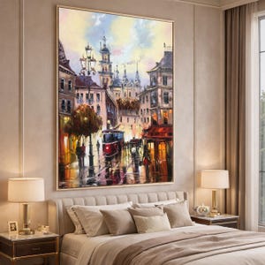May include: An oil painting of a European city street at dusk. The artwork shows buildings with warm lighting, a red tram, and figures walking on a wet street. The sky transitions from yellow to blue.
